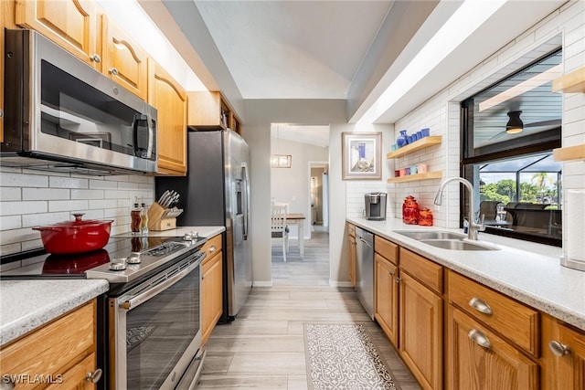 kitchen featuring sink, decorative backsplash, appliances with stainless steel finishes, and light hardwood / wood-style flooring