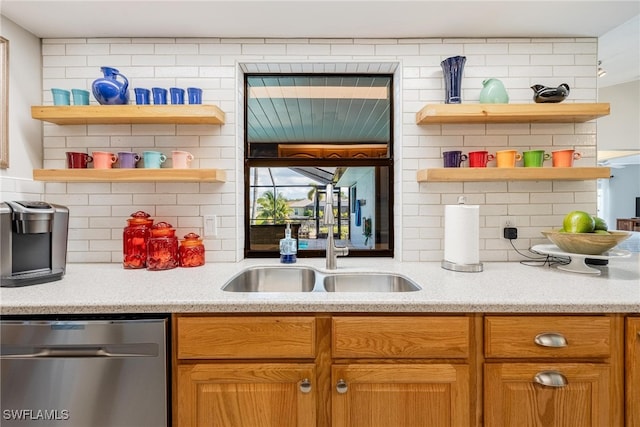 kitchen featuring stainless steel dishwasher, sink, and tasteful backsplash