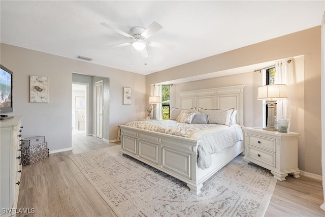 bedroom featuring multiple windows, ceiling fan, and light wood-type flooring