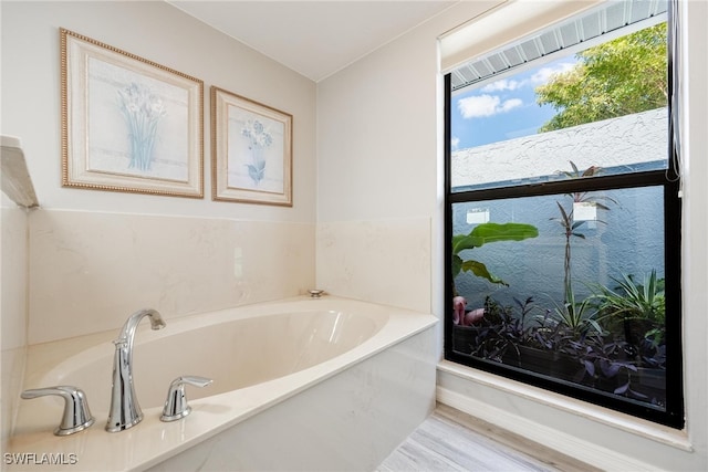 bathroom with hardwood / wood-style flooring and a tub to relax in