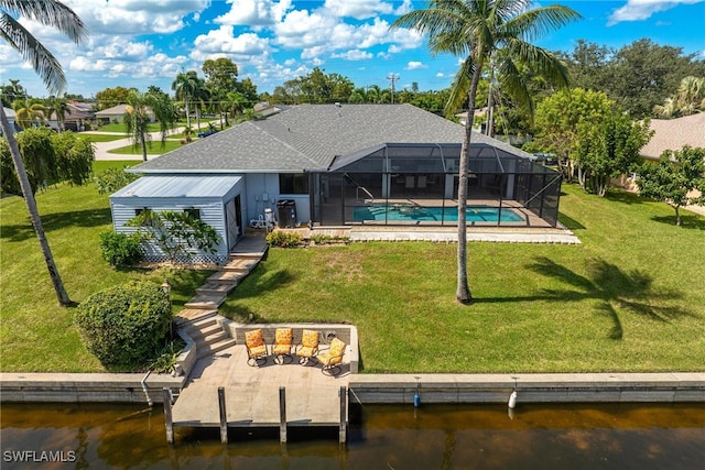 rear view of property with a lawn, a lanai, and a water view