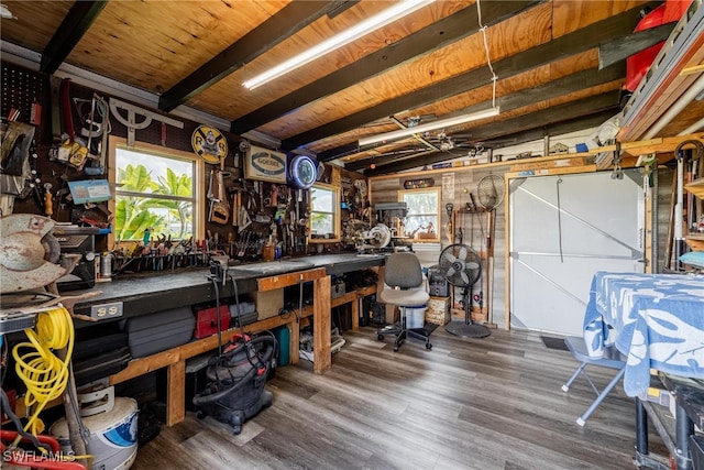 misc room featuring lofted ceiling with beams, hardwood / wood-style floors, and a workshop area