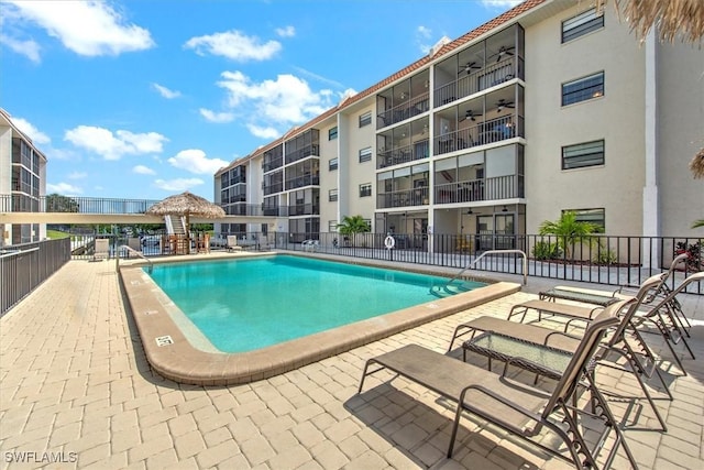 community pool featuring a patio area, fence, and ceiling fan