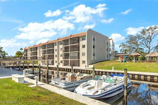 view of dock with a yard and a water view