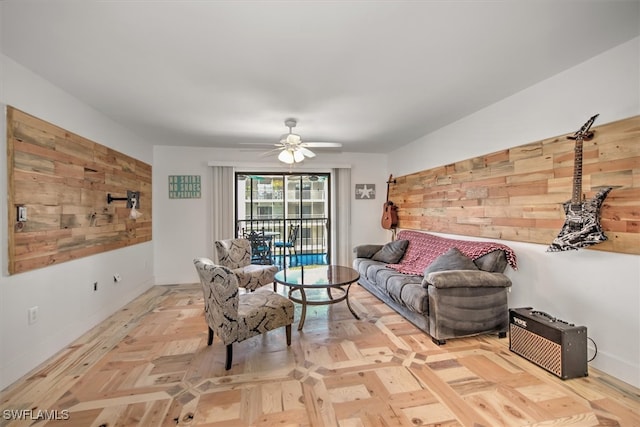 living room with ceiling fan, wood walls, and light parquet flooring