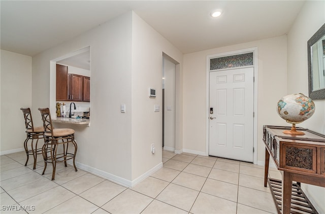 entryway with sink and light tile patterned floors