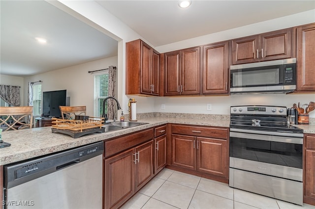 kitchen with stainless steel appliances, sink, and light tile patterned floors