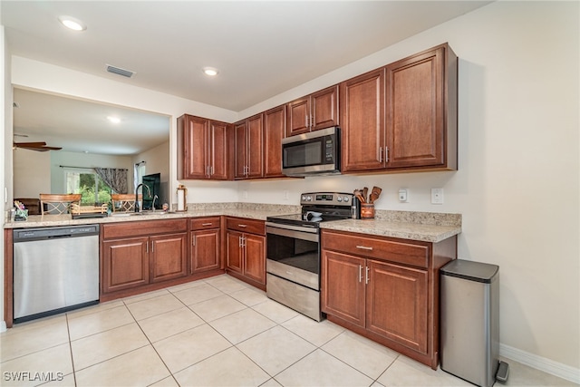 kitchen with ceiling fan, light tile patterned floors, appliances with stainless steel finishes, and sink