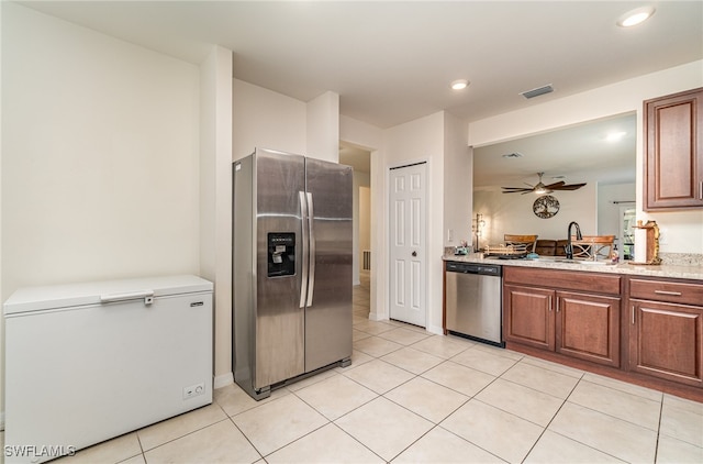 kitchen with light tile patterned floors, ceiling fan, sink, and stainless steel appliances