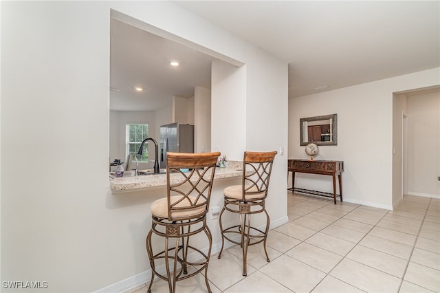 dining area with light tile patterned flooring and sink