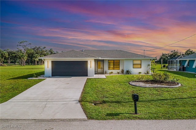 view of front of house with a garage and a lawn