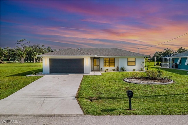 view of front of house with a garage and a lawn