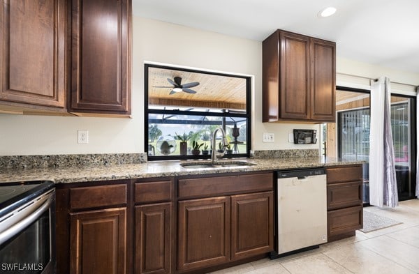 kitchen featuring light stone counters, ceiling fan, light tile patterned floors, sink, and stainless steel appliances