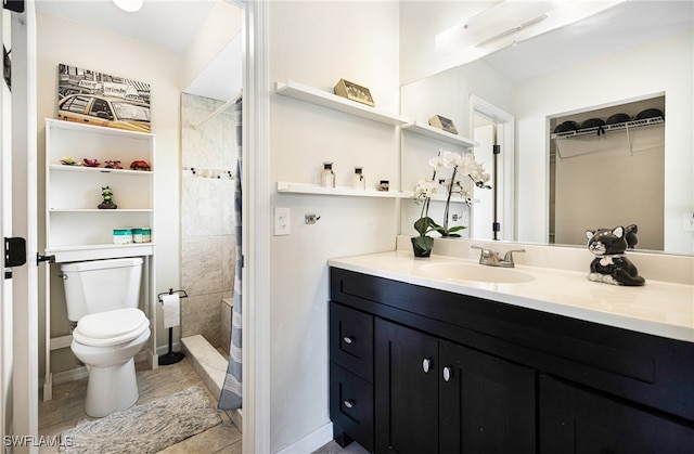 bathroom featuring vanity, a tile shower, and toilet