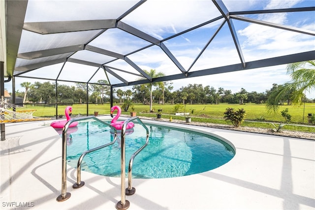 view of swimming pool featuring a yard, a patio area, and a lanai