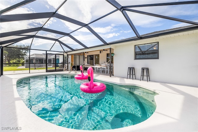 view of pool with a patio and glass enclosure