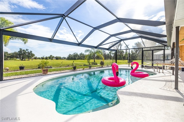 view of swimming pool with a patio, a lawn, and a lanai