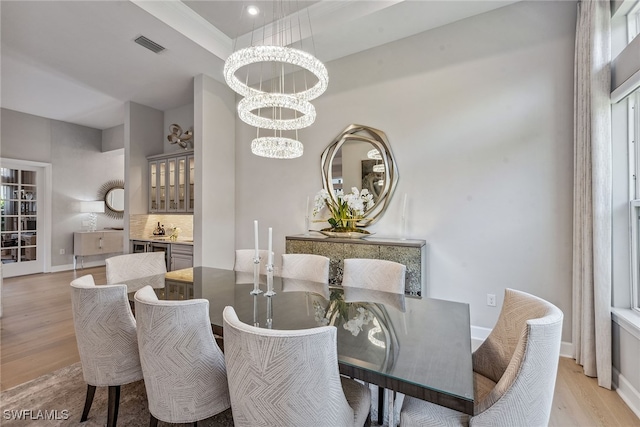 dining area featuring a notable chandelier and light wood-type flooring