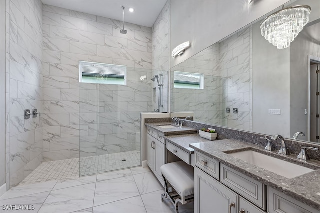 bathroom featuring a tile shower, a notable chandelier, and vanity