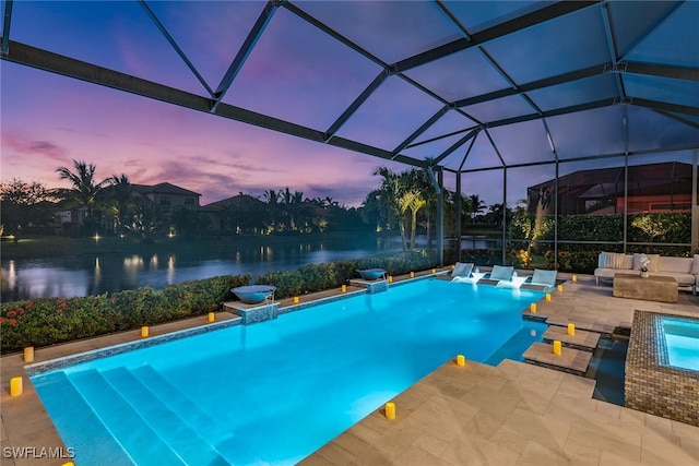 pool at dusk with a lanai, a patio, and a water view