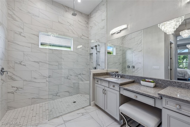 bathroom featuring a tile shower, a chandelier, and vanity