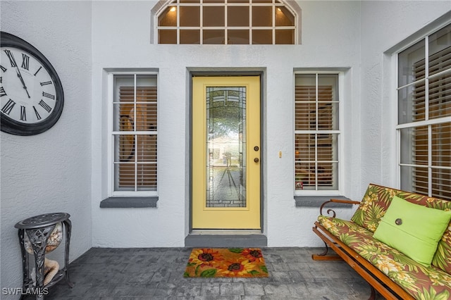 doorway to property featuring stucco siding