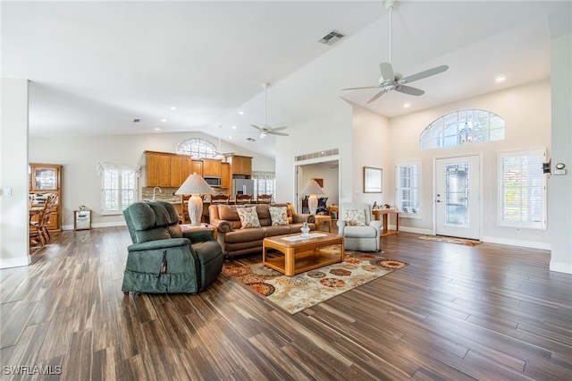 living room with dark wood-style floors, high vaulted ceiling, visible vents, and baseboards