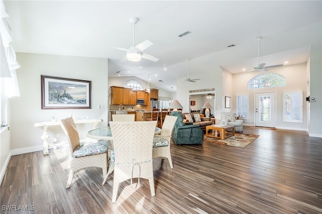 dining room with a healthy amount of sunlight, visible vents, high vaulted ceiling, and dark wood finished floors