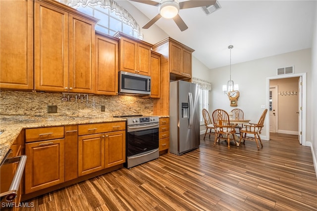 kitchen with vaulted ceiling, stainless steel appliances, light stone counters, and visible vents