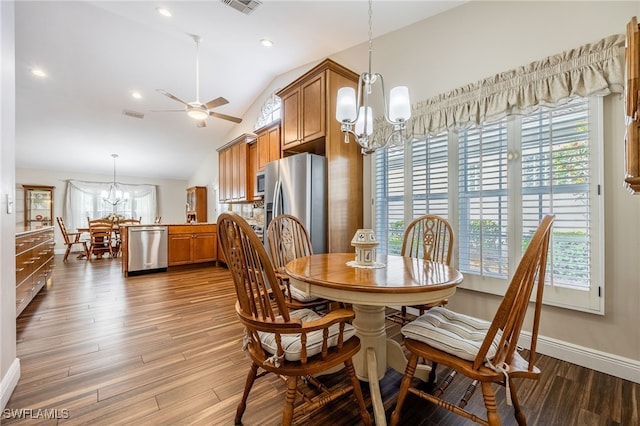 dining room featuring vaulted ceiling, ceiling fan with notable chandelier, light wood-type flooring, and a wealth of natural light