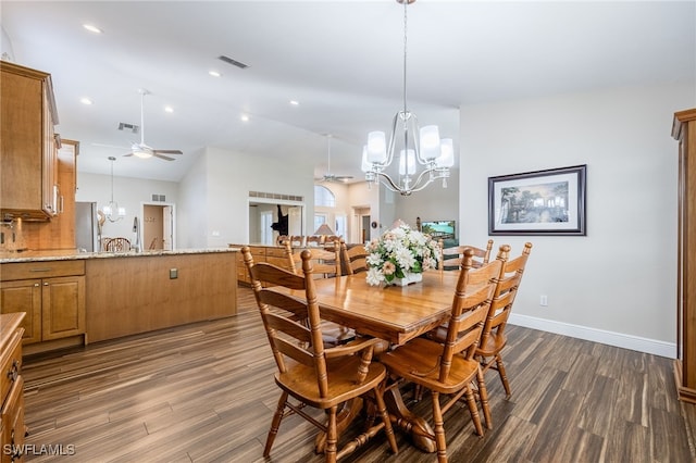 dining space with ceiling fan with notable chandelier, dark wood-style flooring, visible vents, baseboards, and vaulted ceiling