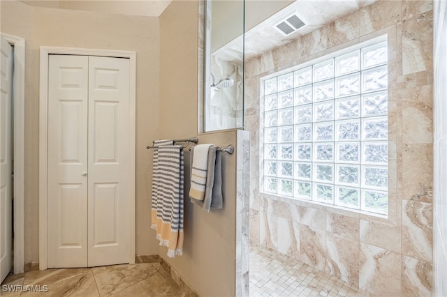 full bathroom with a healthy amount of sunlight, walk in shower, and a closet