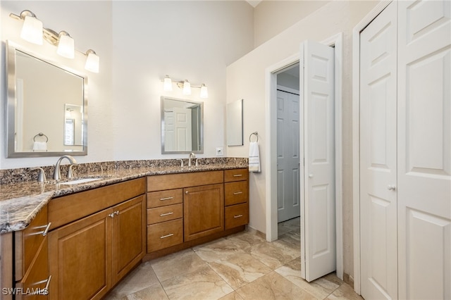 full bathroom featuring a closet, a sink, marble finish floor, and double vanity