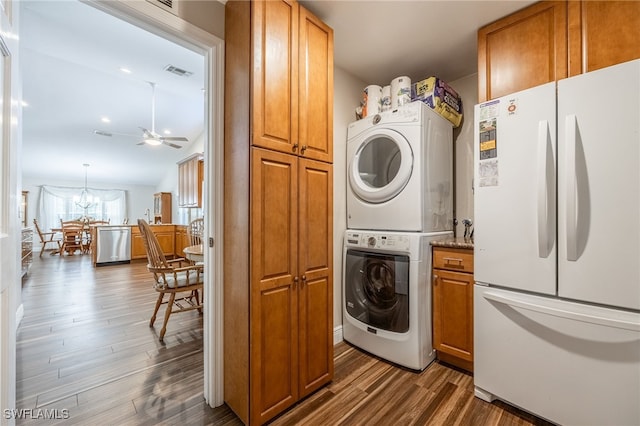 laundry room featuring ceiling fan with notable chandelier, laundry area, dark wood-style flooring, stacked washer / dryer, and visible vents