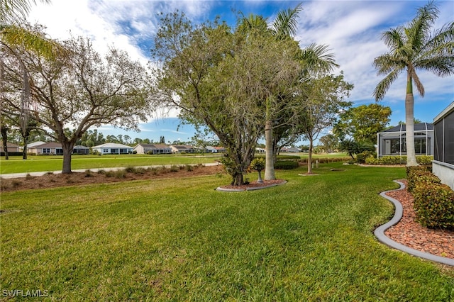 view of yard featuring a lanai and a residential view