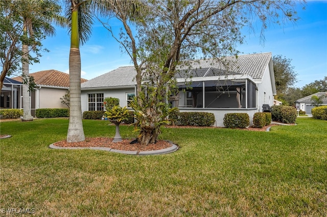 view of front of home with a lanai, stucco siding, a front lawn, and a tiled roof