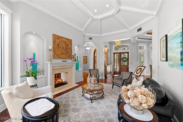 living room with vaulted ceiling with beams, a high end fireplace, and wood-type flooring