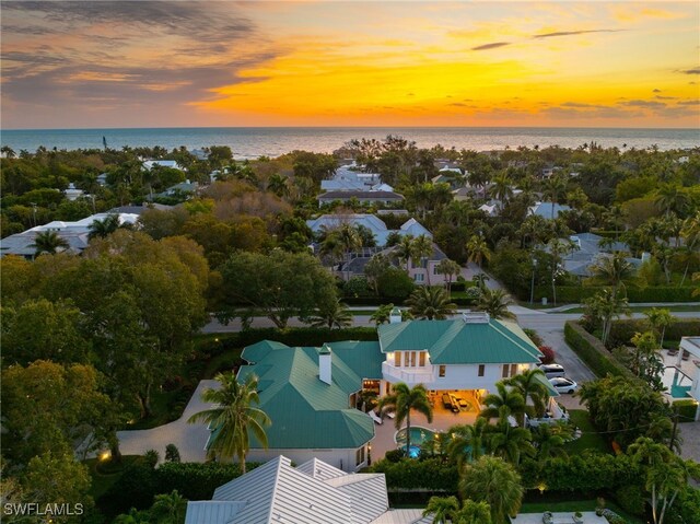 aerial view at dusk featuring a water view