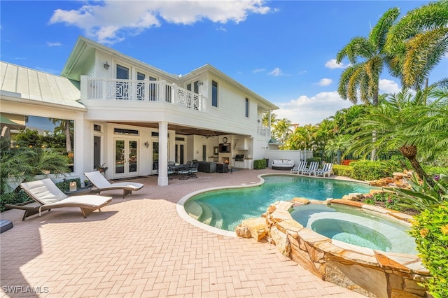 view of pool with an in ground hot tub, french doors, a patio, and outdoor lounge area