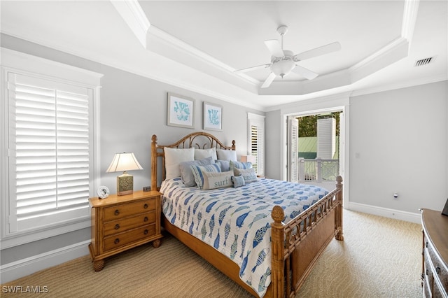 bedroom with a raised ceiling, ceiling fan, crown molding, and light colored carpet