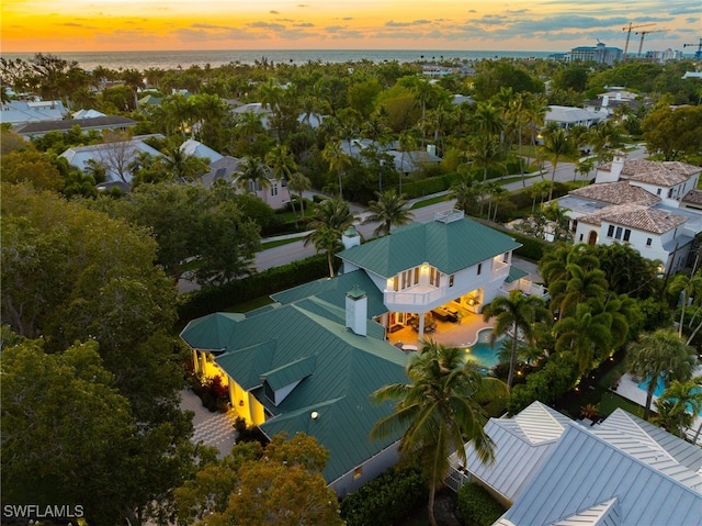 aerial view at dusk featuring a water view