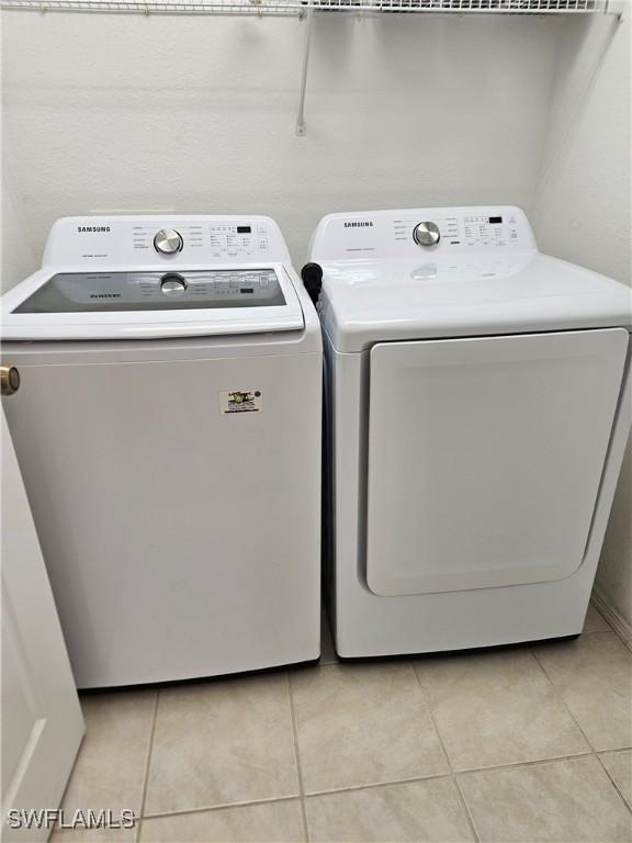 laundry area featuring washer and dryer and light tile patterned floors