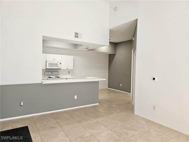 kitchen featuring visible vents, white cabinets, light tile patterned floors, light countertops, and white appliances