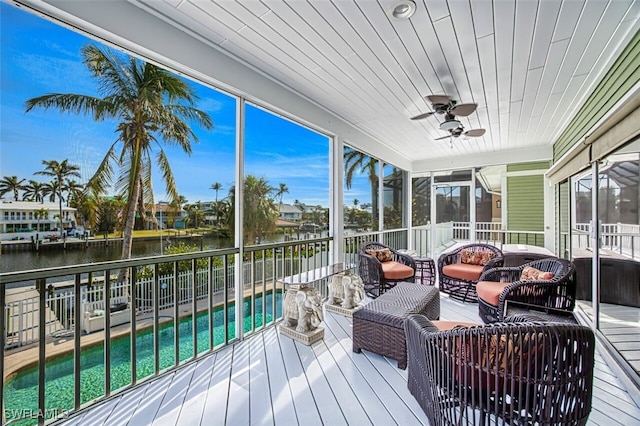 sunroom / solarium with ceiling fan, a water view, and wooden ceiling