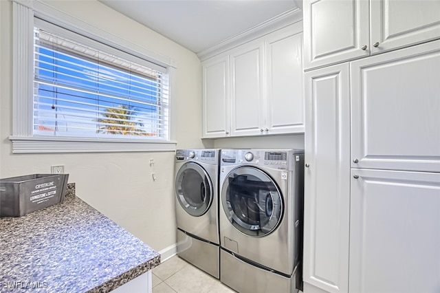 clothes washing area featuring cabinets, separate washer and dryer, and light tile patterned flooring