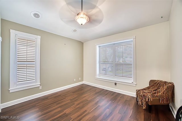 living area featuring ceiling fan and dark hardwood / wood-style flooring