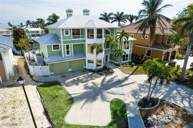 18141 Old Pelican Bay Dr, Fort Myers Beach, FL 33931 - raised beach house with a balcony, a metal roof, an attached garage, driveway, and a gate