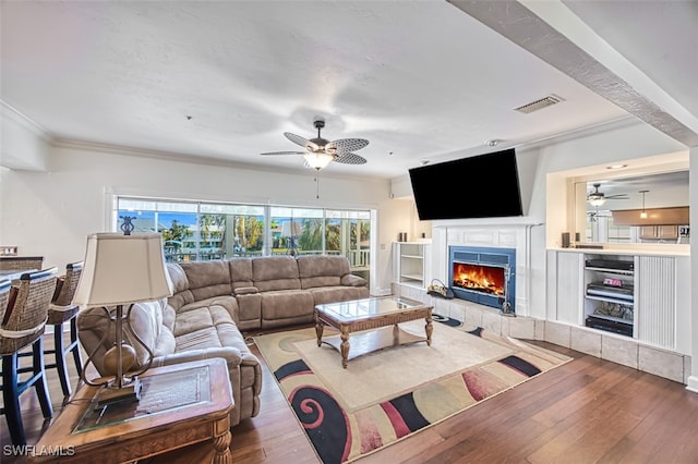 living room with a fireplace, hardwood / wood-style floors, and crown molding