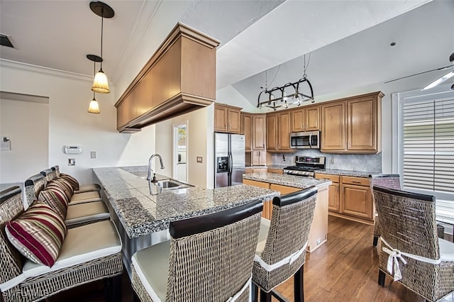 kitchen with pendant lighting, crown molding, dark hardwood / wood-style floors, appliances with stainless steel finishes, and kitchen peninsula