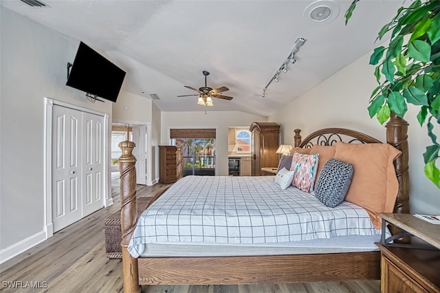 bedroom featuring a closet, ceiling fan, light hardwood / wood-style flooring, and lofted ceiling